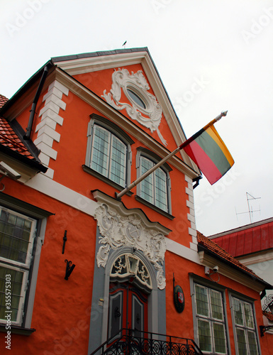 old houses in the town.  Red ancient building with the flag of Lithuania.