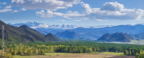 Panoramic view, mountain landscape. Spring mountain slopes and picturesque sky with white clouds.