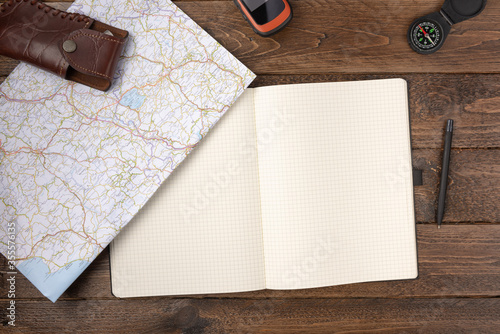 Travel planning concept. Traveler accessories. Gps navigator with blank notepad, map and compass on wooden table background. Travel vacation concept. Flat lay, top view.