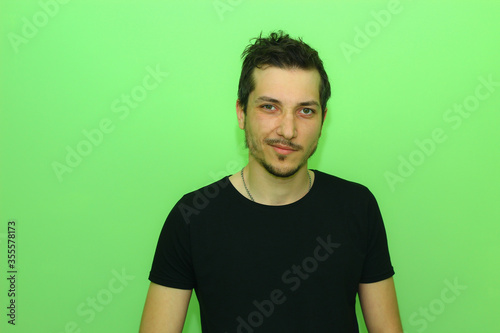 young man or guy on a light green background. Emotion of contempt photo