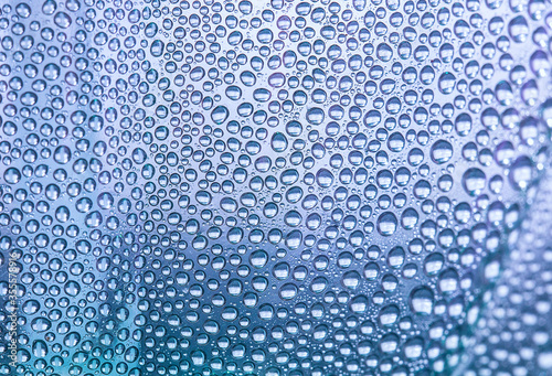 Close up water drops on light lilac tone background. Abstract light lilac wet texture with water drops on glass surface. Selective focus