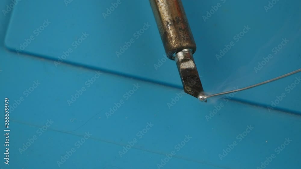 Soldering iron close-up melts the tin.The molten solder.