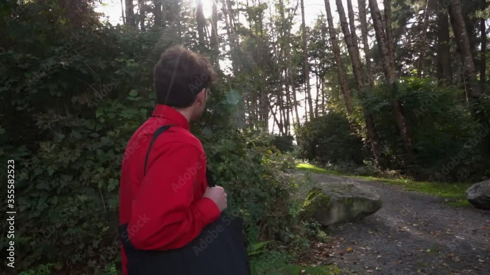 Man goes for walk through forest during golden hour Man goes for walk through forest during golden hour