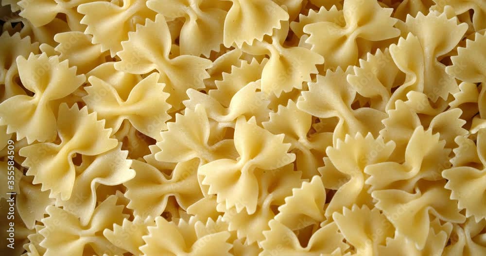A lot of dry Farfalle pasta slowly rotates. A lot of dry Farfalle pasta slowly rotates.