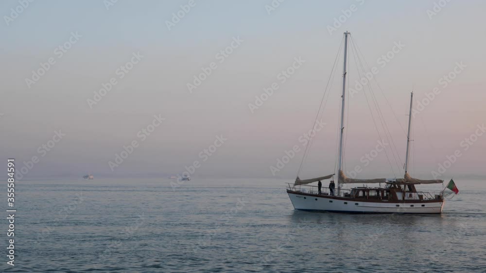 Slow motion of boat sailing on calm waterbody at dusk in Lisbon, Portugal. Slow motion of boat sailing on calm waterbody at dusk in Lisbon, Portugal.