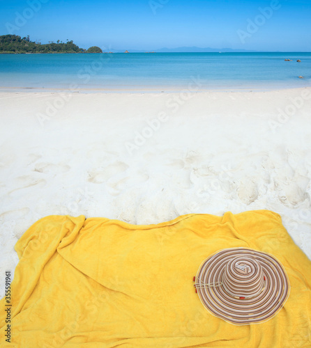Fototapeta Naklejka Na Ścianę i Meble -  Yellow towel with hat on beach and sea