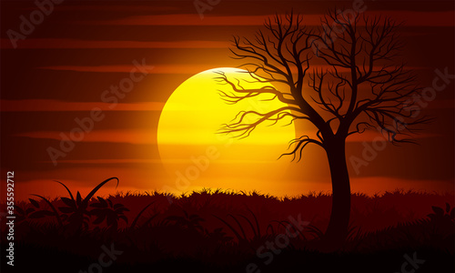 Sunset landscape with a dead tree silhouette.