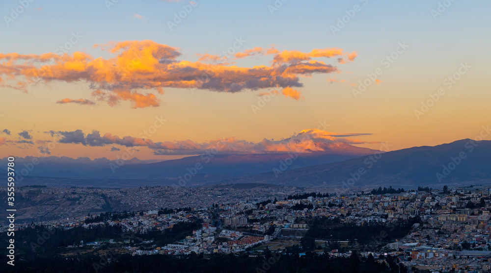 Impressive landscape of the Cayambe volcano at sunset with the skyline of Quito city, Ecuador.