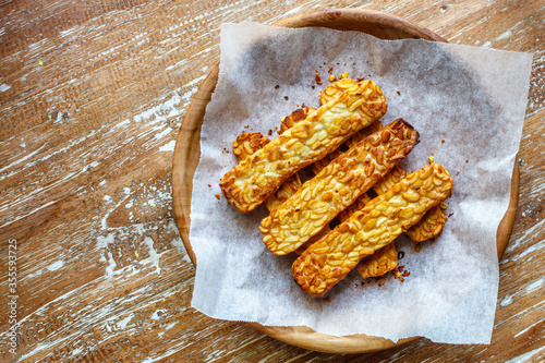 Фотография Fried tempeh or tempe, traditional Indonesian soy product, on a wooden tray