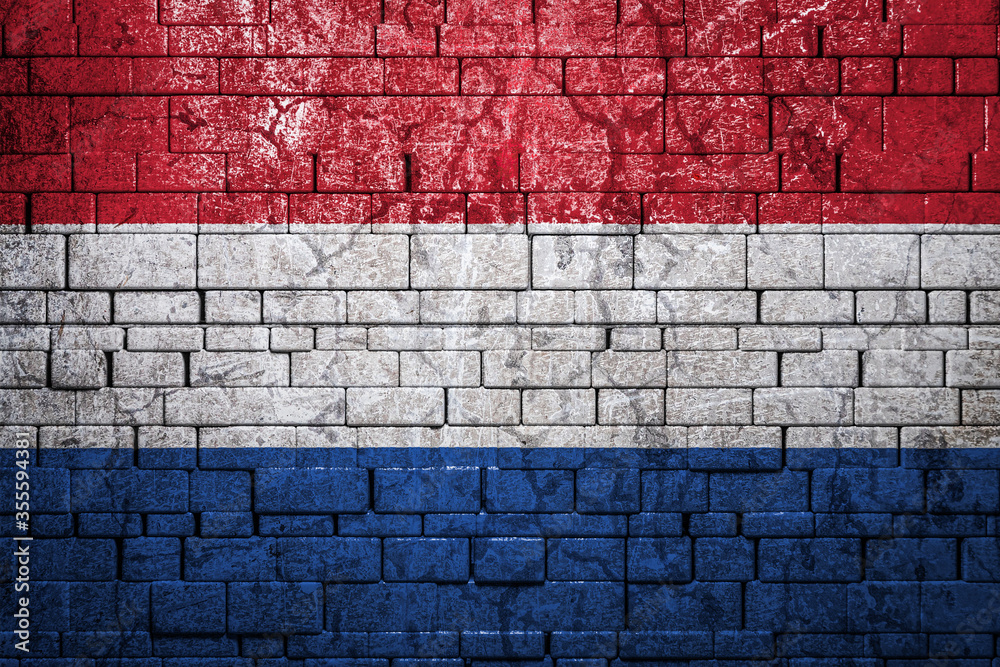 National flag of Netherlands on brick wall background.The concept of national pride and symbol of the country. Flag banner on stone texture background. National flag of Netherlands on brick wall background.The concept of national pride and symbol of the country. Flag banner on stone texture background.