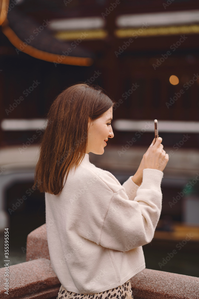 Φωτογραφία brunette girl taking photos on her phone of a pagoda in Yuyuan market in Shangha