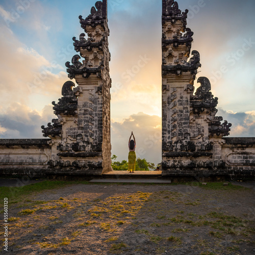 One unrecognisable woman praying at the entrance of a temple, Bali, Indonesia