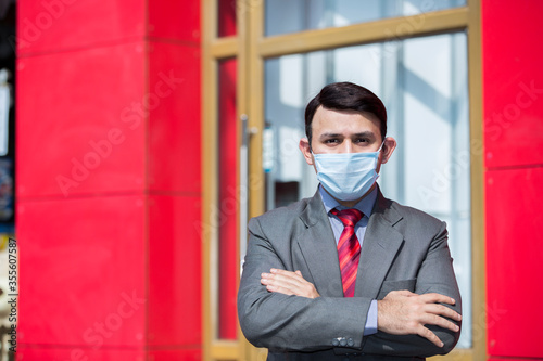 Businessman wearing face mask due to impact of pandemic coronavirus