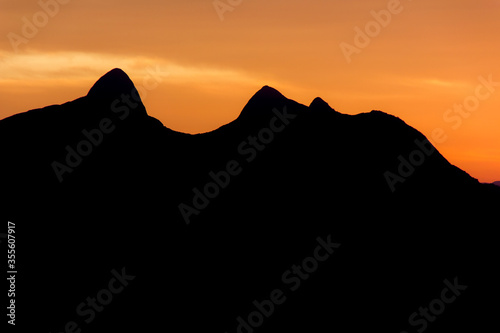 Silhouette of the mountain known as stone woman during sunrise in Teresopolis. photo