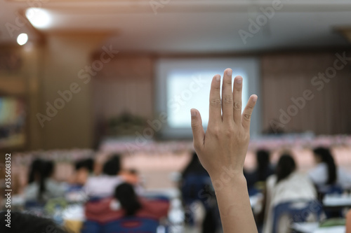 Audience or students raising hands up at conference to answer question while speaker speech at seminar hall with crowd groups, arms of large group in classroom for vote or questions