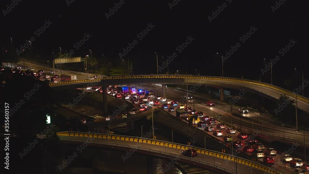 An ambulance with a flashing light stuck in a traffic jam at night. A big traffic jam due to which an ambulance will be late for help. An ambulance with a flashing light stuck in a traffic jam at night. A big traffic jam due to which an ambulance will be late for help.