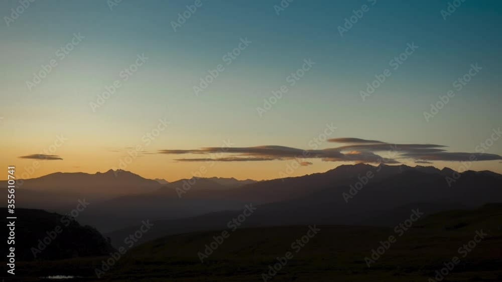 Top view of the Caucasus mountains in the spring season under the twilight sky against the background of beautiful sunset horizon and small clouds. Evening timelapse nature of Republic of Adygea. Top view of the Caucasus mountains in the spring season under the twilight sky against the background of beautiful sunset horizon and small clouds. Evening timelapse nature of Republic of Adygea.