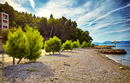Amazing sunset at rocky beach near Brela town, Makarska riviera, Dalmatia, Croatia. Adriatic sea. Beautiful world of Mediterranean countries.