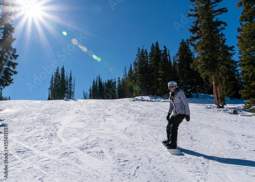 A woman snowboards down Beaver Creek, Colorado on a perfect sunny, blue bird day.  It doesn't get much better than this!