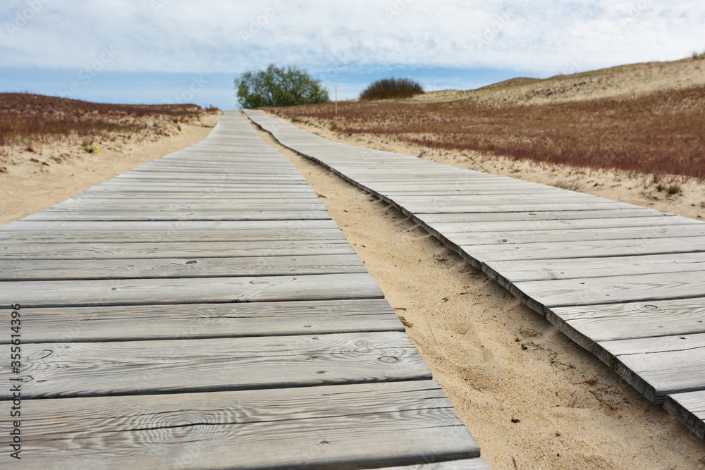 Wooden path leading through dunes at Nagliai nature reserve near Nid