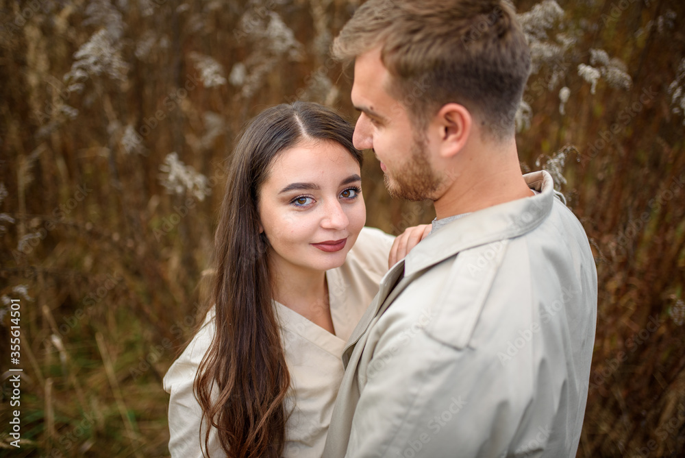 Close up of a beautiful young happy couple in love embracing while spending time in the autumn park Close up of a beautiful young happy couple in love embracing while spending time in the autumn park
