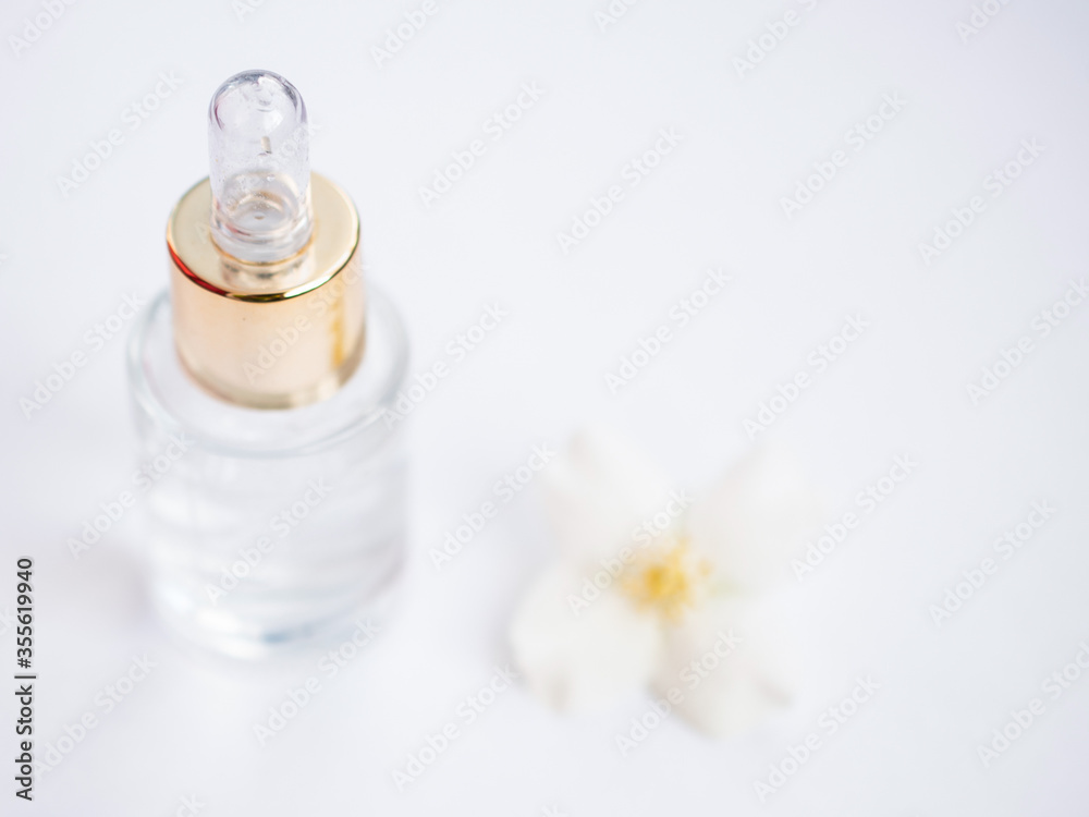 Jasmine essential oil (tincture, remedy, infusion). Glass bottle with fresh jasmine flowers on a white background. Flower essential oil. Phytotherapy. View from above Jasmine essential oil (tincture, remedy, infusion). Glass bottle with fresh jasmine flowers on a white background. Flower essential oil. Phytotherapy. View from above