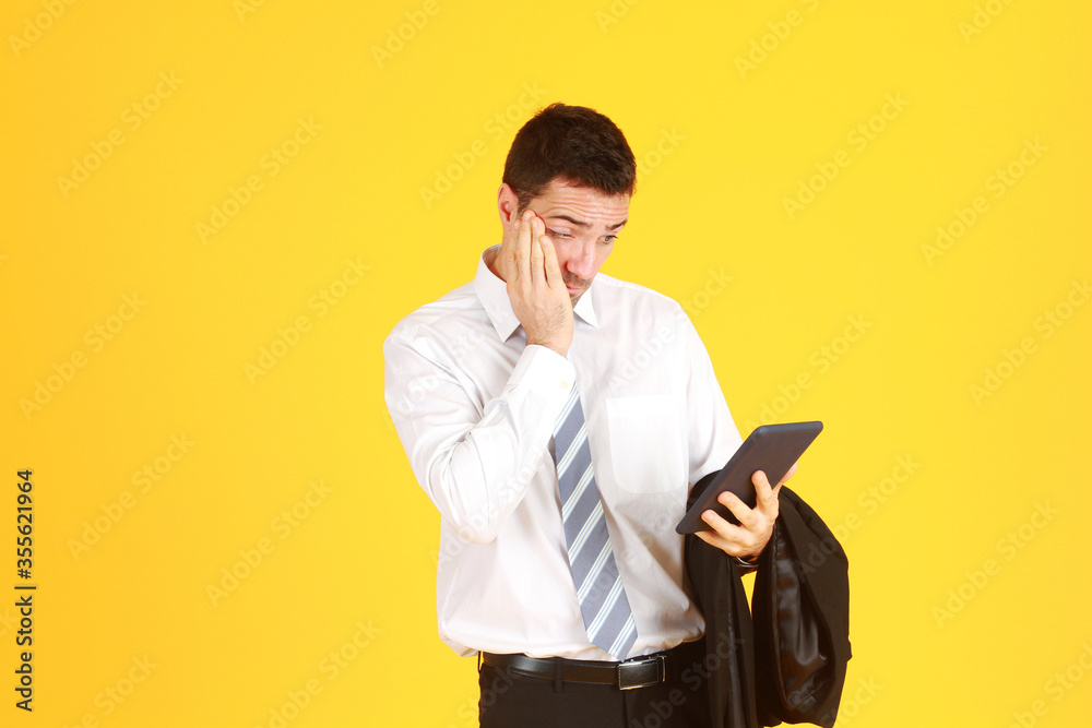 Handsome and smart engineer in suit and white shirt and Wearing a white safety engineering hat with hand holding smartphone Serious and stressed with work isolated on yellow background. Copy Space Handsome and smart engineer in suit and white shirt and Wearing a white safety engineering hat with hand holding smartphone Serious and stressed with work isolated on yellow background. Copy Space