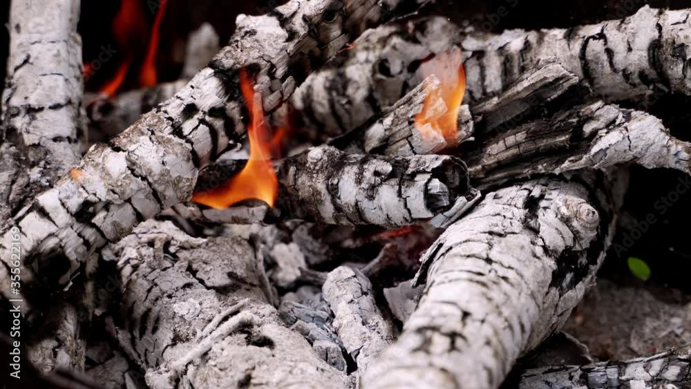 Background of smoldering charcoal. White wooden embers in slight fire. Hot smoldered logs ready for barbecue. Close-up. Background of smoldering charcoal. White wooden embers in slight fire. Hot smoldered logs ready for barbecue. Close-up.