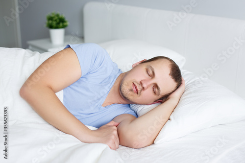 portrait of young man sleeping in bed