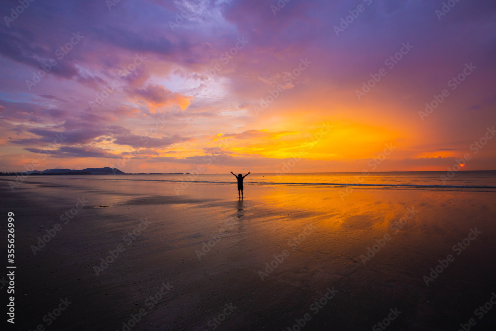 Silhouette of a man walking on the beach at sunset. Freedom life in holiday