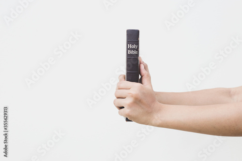 Wallpaper Mural Woman with Bible praying, hands clasped together on her Bible on wooden table. Torontodigital.ca