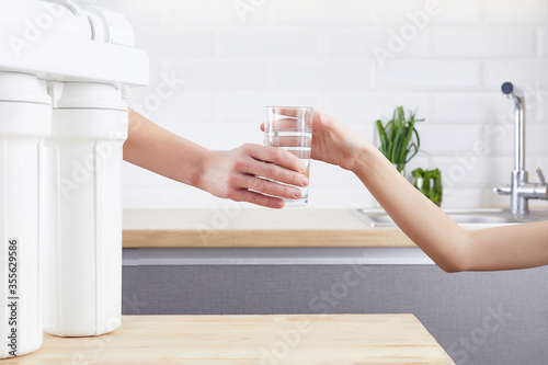Female Hand giving a glass of clean water. Purified water and healthy life concept. photo
