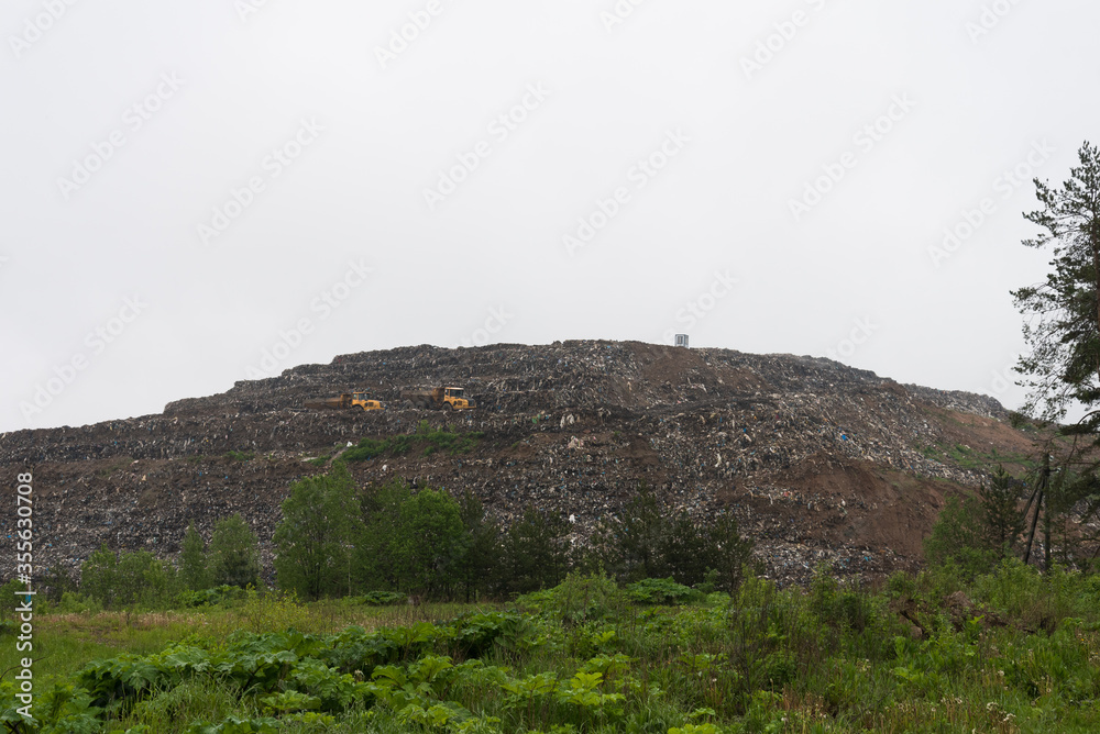 A huge landfill. Special cars drive on the mountain of garbage. Environmental pollution. Environmental disaster. A huge landfill. Special cars drive on the mountain of garbage. Environmental pollution. Environmental disaster.