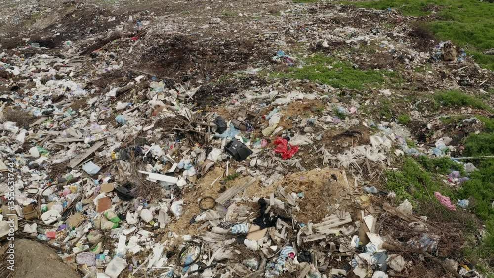 Aerial view of garbage dump near agricultural field, earth pollution aerial view