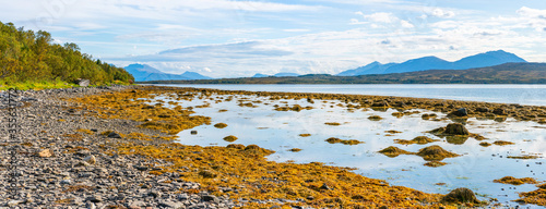 Panoramic view of the Sandnessundet strait and Kvaloya from stony shores of Hakoya island in Tromso Municipality in Troms county, Norway