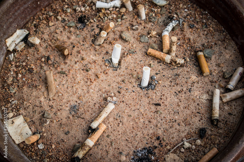 Cigarette butts in yellow sand. Problem of humanity. Cigarette smoking, bad habit. Nicotine addiction. Garbage. vintage style.