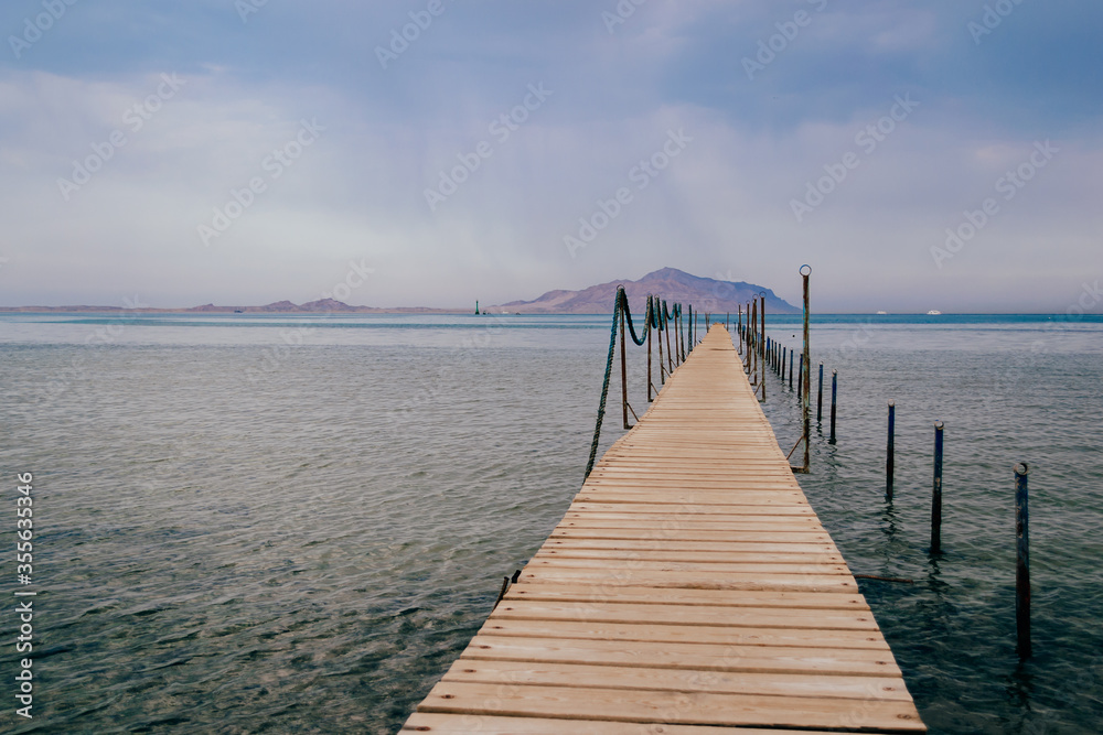Old wooden pier on the Red sea at overcast day