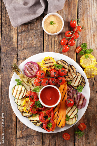grilled colorful vegetable, bell pepper, zucchini, onion, tomato, carrot and dip sauce