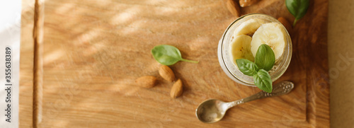 Vegan Chia Pudding with Banana and almond on wooden background. Vegan, morning, breakfast, healthy eating concept. Banner for website