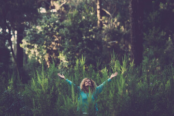 Happy people woman happy in the middle of the wood forest with trees and plants everywhere around - save and respect nature no deforestation business activity - earth's day event celebration day