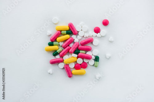Assorted many colored pills, capsules and tablets on white background