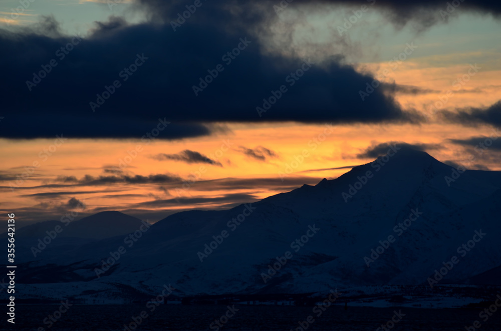 colorful dawn sky over snowy mountain and sea