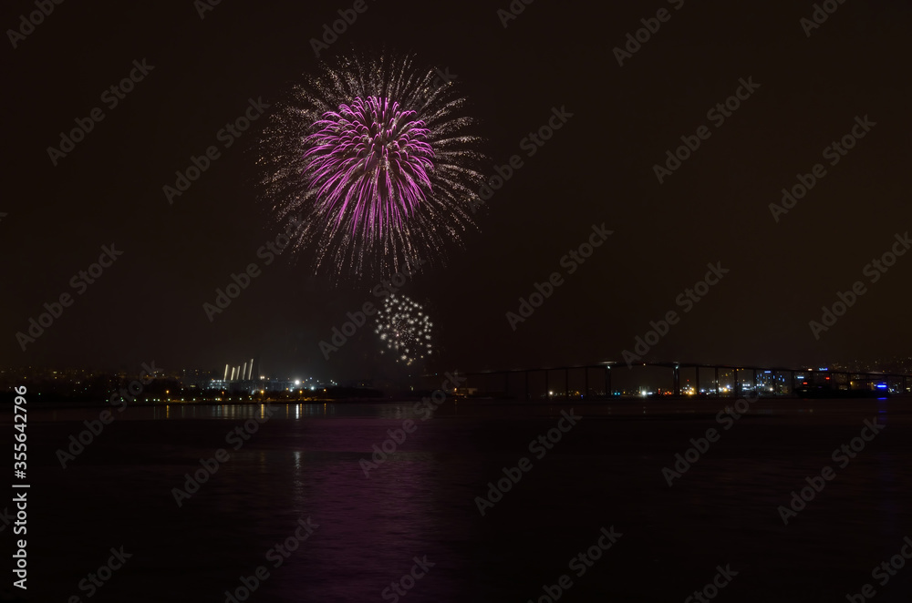 Beautiful firework on night sky in tromsoe city with bridge, cathedral and colorful reflection on the cold fjord water surface on new years eve Beautiful firework on night sky in tromsoe city with bridge, cathedral and colorful reflection on the cold fjord water surface on new years eve