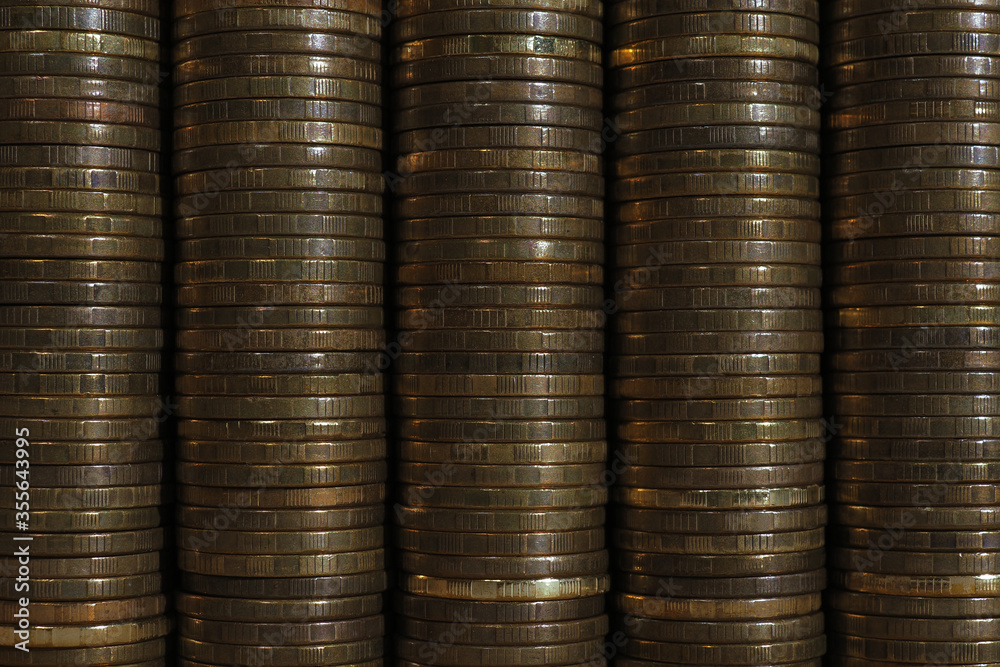 Background or wall from piles and edges of yellow coins close-up. Ten Russian rubles. Dark textured horizontal wallpaper for economic, banking or financial topics. Macro Background or wall from piles and edges of yellow coins close-up. Ten Russian rubles. Dark textured horizontal wallpaper for economic, banking or financial topics. Macro