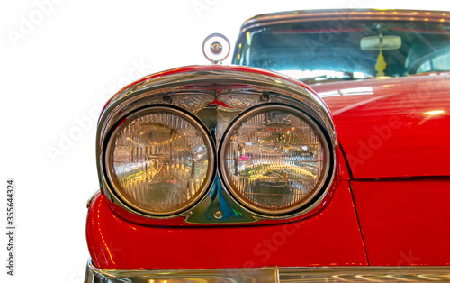 Classical American Vintage car 1958. White background. Front lights detail.