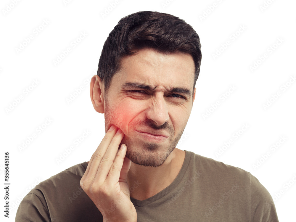 Young man touching his cheek with expression of horrible suffer from pain, health problem and aching tooth, isolated on gray background. Toothache concept Young man touching his cheek with expression of horrible suffer from pain, health problem and aching tooth, isolated on gray background. Toothache concept