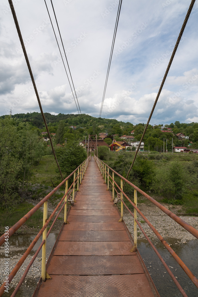 Obraz premium A Red Iron Bridge Crossing the Prahova River (Romania)