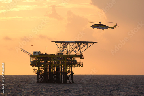 A helicopter on top of a offshore oil-platform transporting roughnecks 