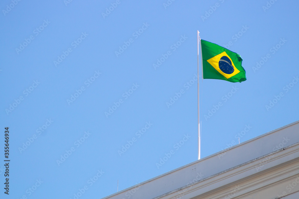 Brazilian flag outdoors on top of a building on Copacabana beach.