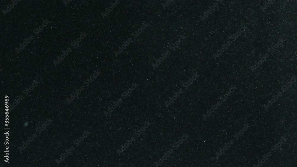 Slow motion air bubbles floating in water on black background